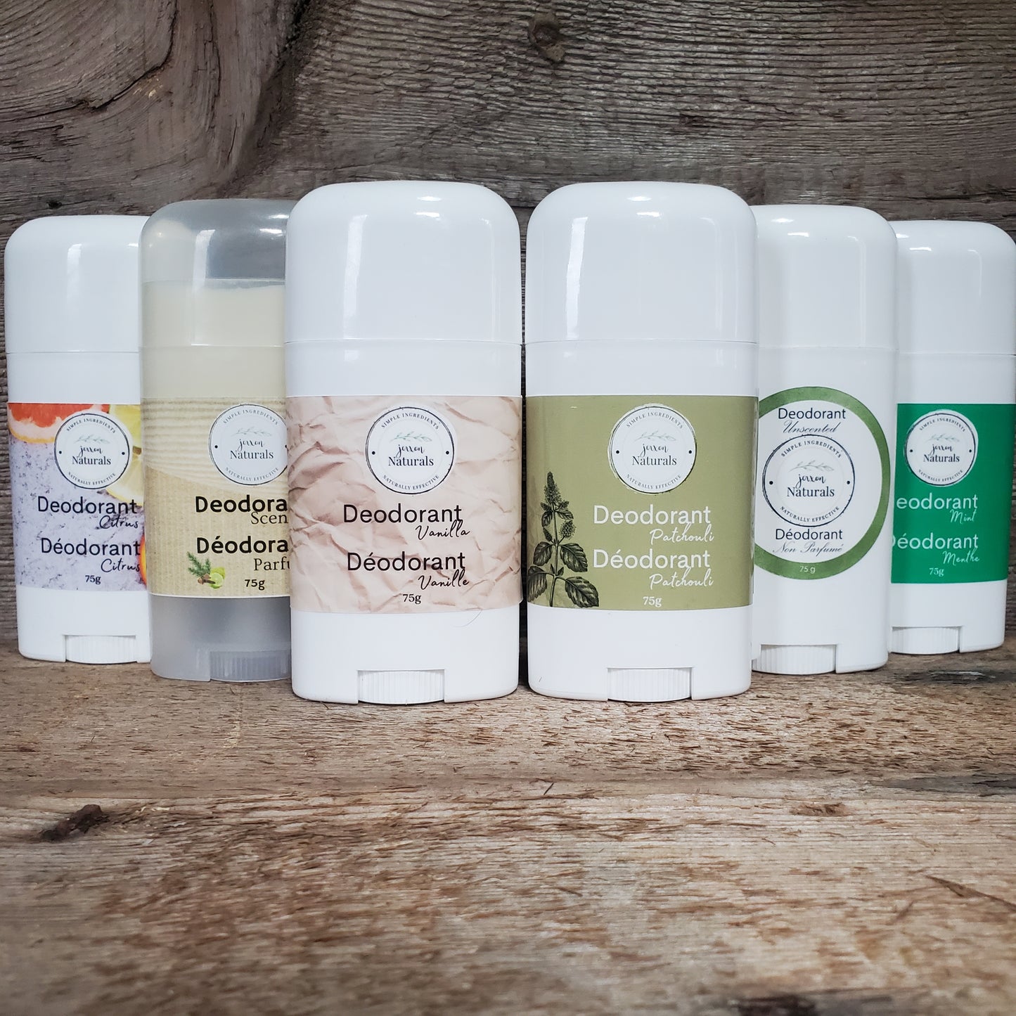 A range of natural deodorant sticks displayed horizontally in a line, with various labels indicating different scents such as citrus and mint.