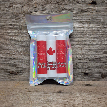 Jaxon Naturals Canada lip balm collection featuring three handcrafted Canadian-themed lip balms displayed on rustic barn board.