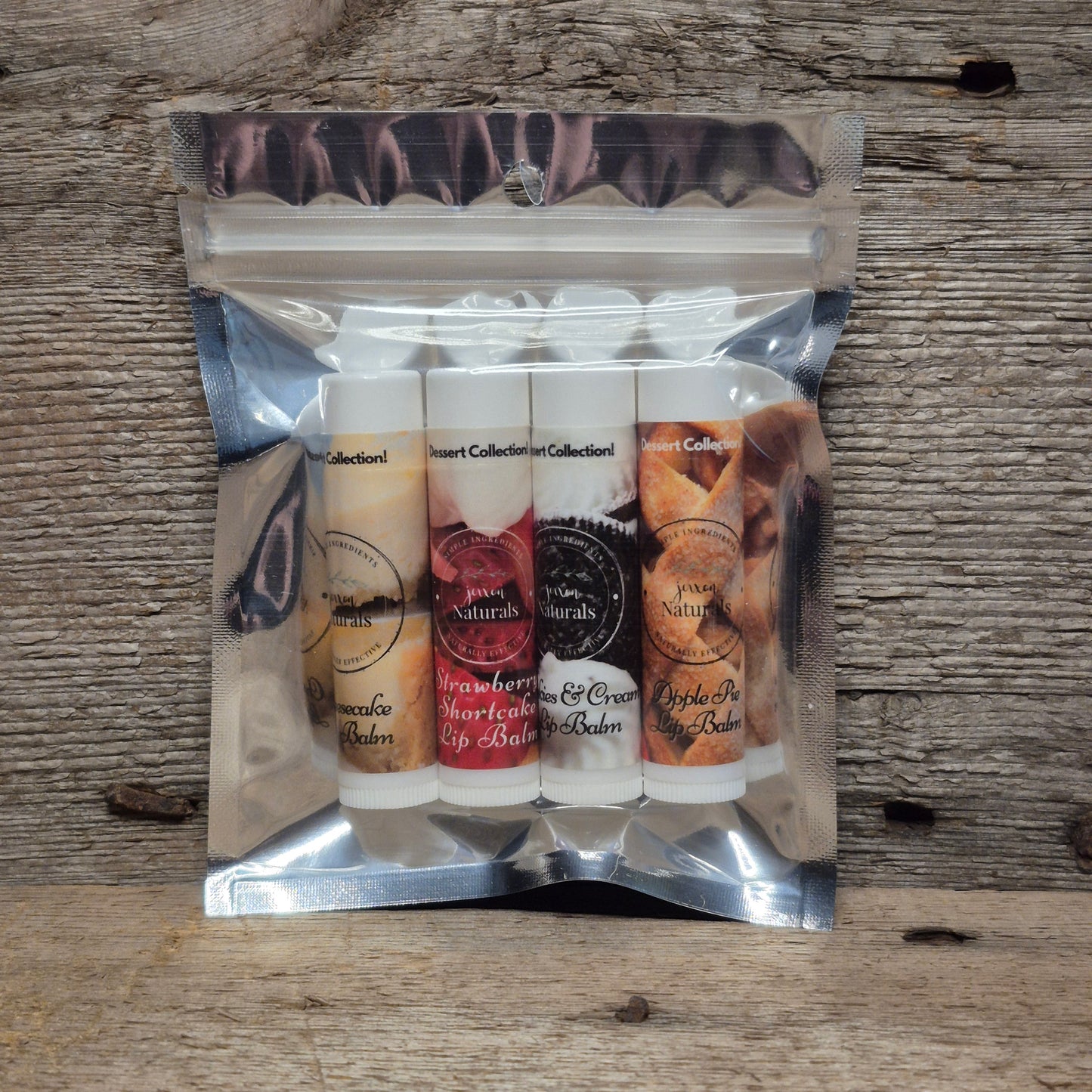 Jaxon Naturals Dessert lip balm collection with four sweet-inspired handcrafted lip balms displayed on rustic barn board.