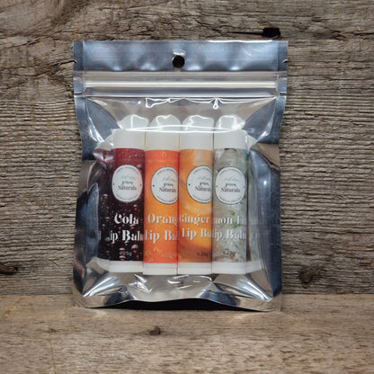 Jaxon Naturals Pop Lip Balm Collection featuring four handcrafted lip balms displayed on rustic barn board.
