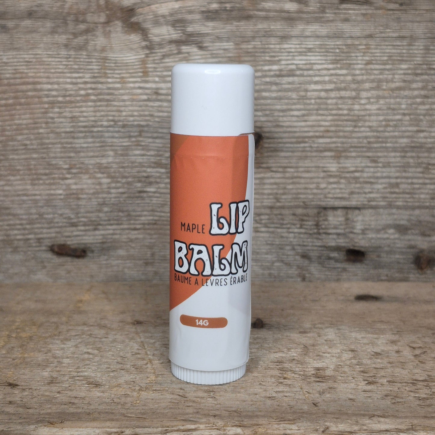 Jaxon Naturals Maple Jumbo Balm Stick displayed on rustic barn board.