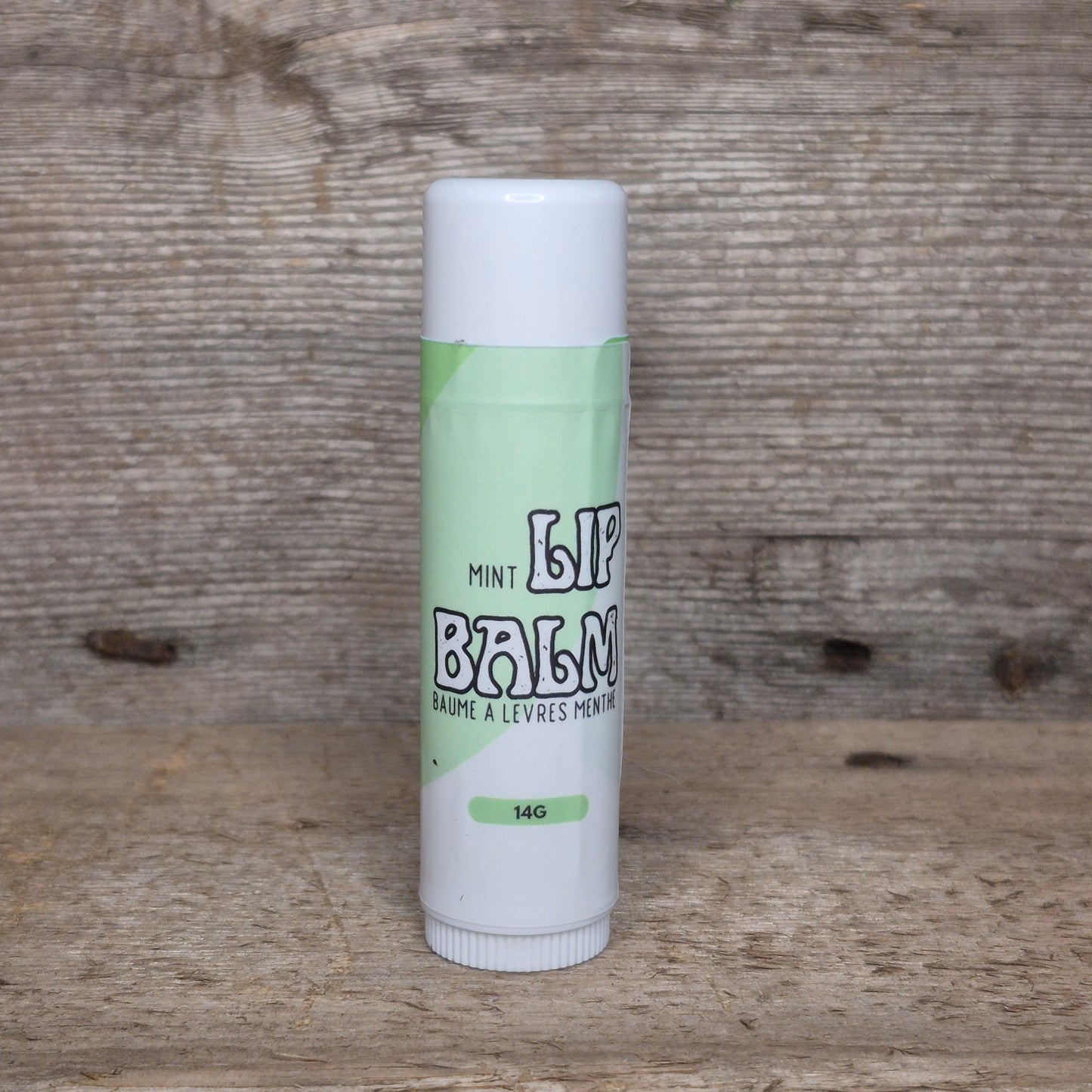 Jaxon Naturals Mint Jumbo Balm Stick displayed on rustic barn board.