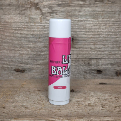 Jaxon Naturals Raspberry Jumbo Balm Stick displayed on rustic barn board.