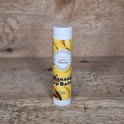Jaxon Naturals limited edition banana lip balm displayed on rustic barn board.