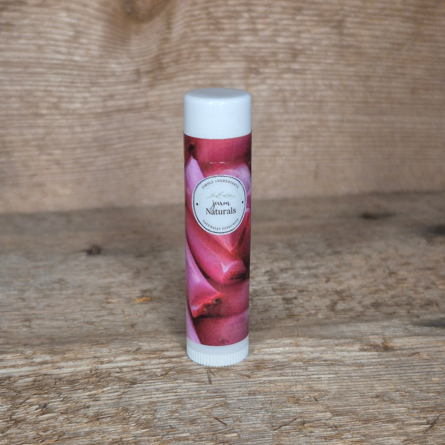 Jaxon Naturals limited edition chicken bone lip balm displayed on rustic barn board.