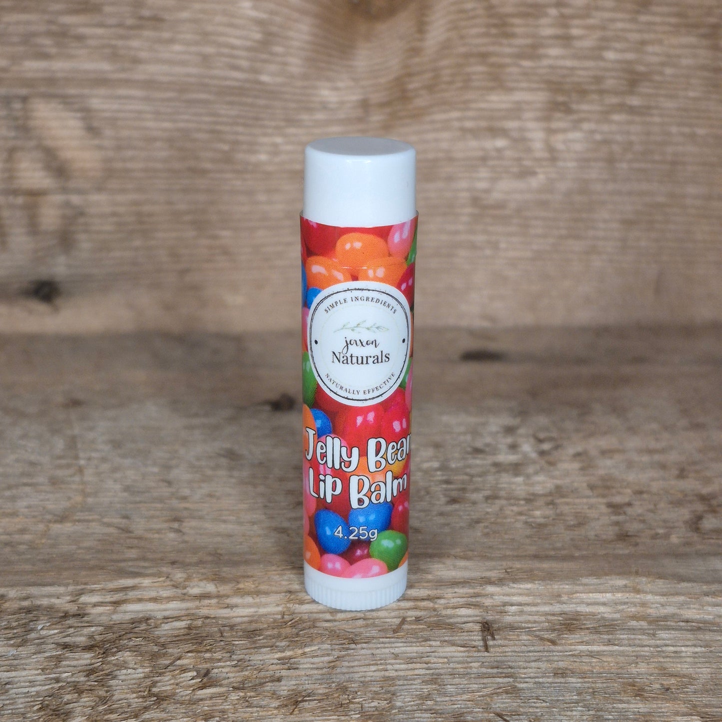 Jaxon Naturals limited edition jelly bean lip balm displayed on rustic barn board.