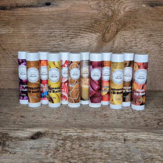 Jaxon Naturals limited edition lip balm collection displayed on rustic barn board featuring handcrafted seasonal and specialty lip balms.