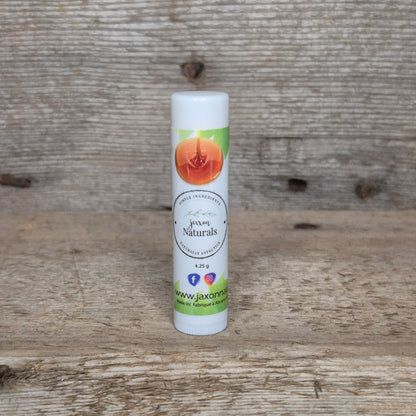 Jaxon Naturals Maple Lip Balm in a recyclable tube, handcrafted with natural ingredients and displayed on rustic barn wood.