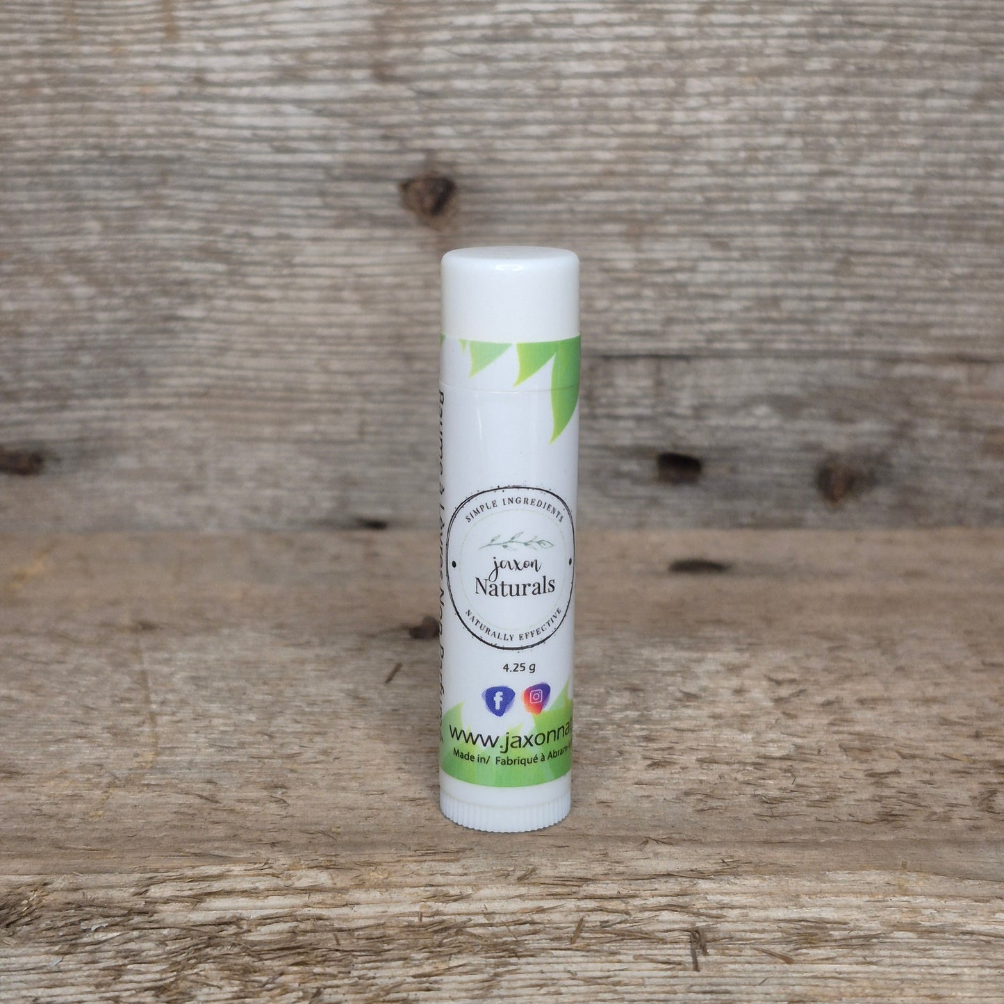 Jaxon Naturals Unscented Lip Balm in a recyclable tube, handcrafted with natural ingredients and displayed on rustic barn wood.